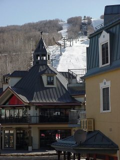 Trails and lifts of the Versant Sud rise above the Village.