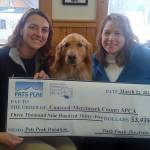 Shannon Camara, Manager of Communications at Concord-Merrimack County SPCA, receives a check for $3,935 from Lori Rowell, Director of Marketing at Pats Peak, and Roxy, the ski area's golden retriever mascot. (photo: Pats Peak)