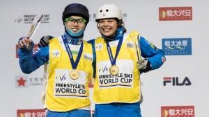 Ashley Caldwell (USA) and Guangpu Qi (CHN) wear yellow World Cup bibs after winning the aerials opener on Saturday in Beijing, China. (photo: Ronnie Yan/FIS)