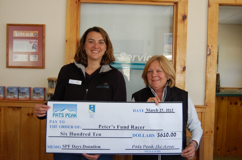 Bertie Holland (R), a representative from Peter’s Fund Racer, receives a $610 check from Lori Rowell, Director of Marketing at Pats Peak, as part of the New Hampshire ski area's “SPF Days Go Sun Smart” special. (photo: Pats Peak)