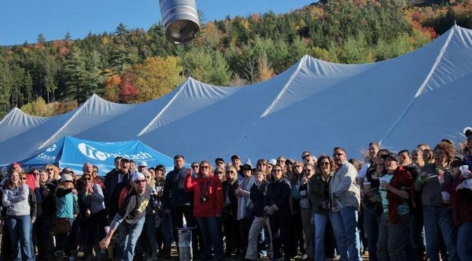 A participant in the annual Attitash Oktoberfest Keg Toss gives it all he's got to throw an empty keg as far as possible. (file photo: Attitash Mountain Resort)