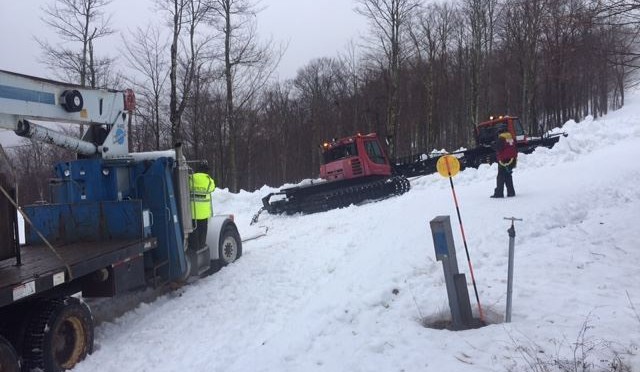 Workers use two snowcats to pull a stuck boom truck into place. (photo: Timberline Four Seasons Resort)